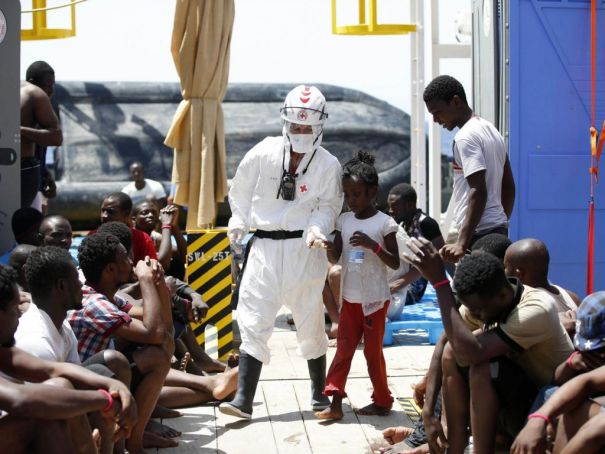 A member of Italy's Red Cross assists an unaccompanied child in Sicily.